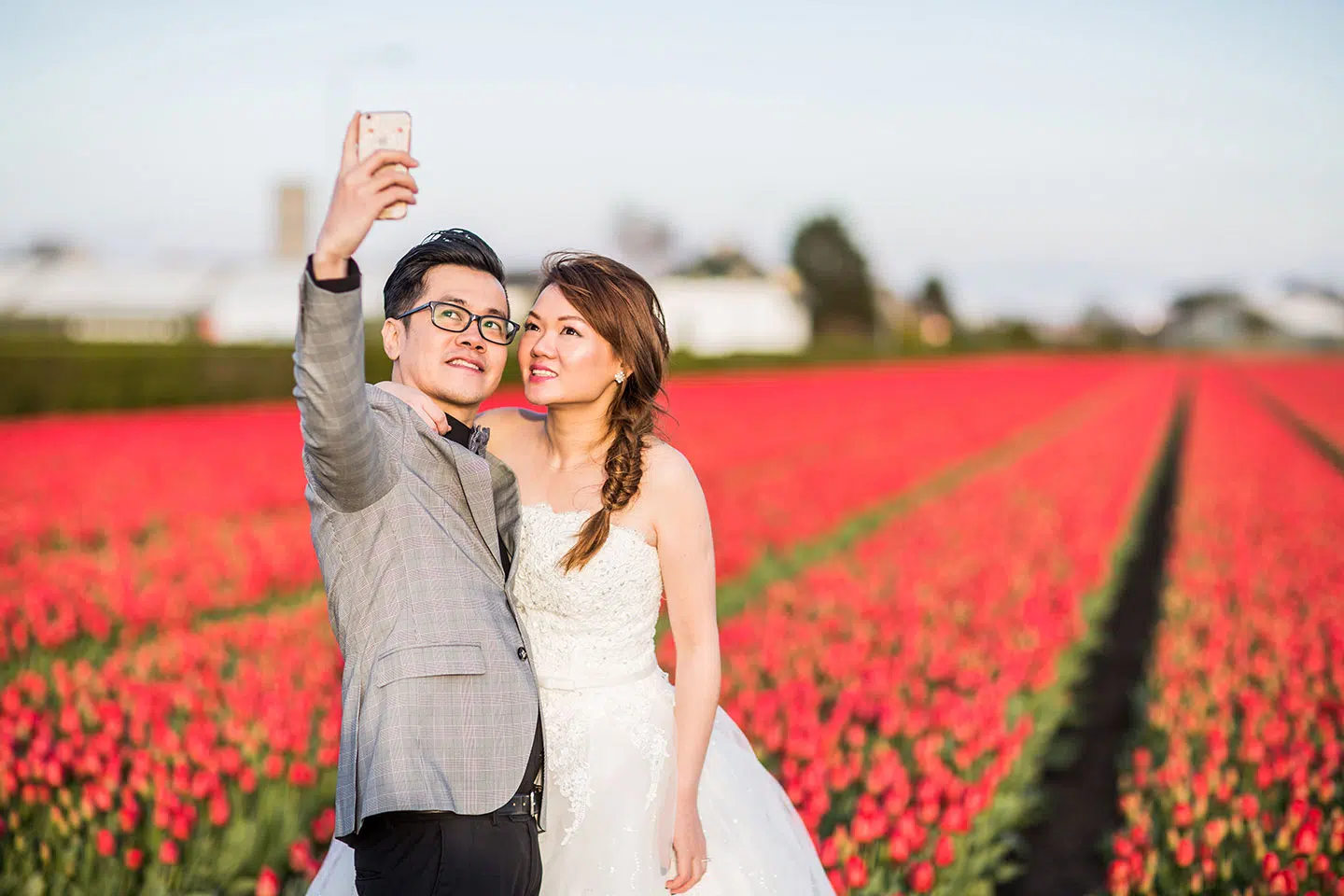 Couple takes a selfie during their prewedding shoot in the tulip fields