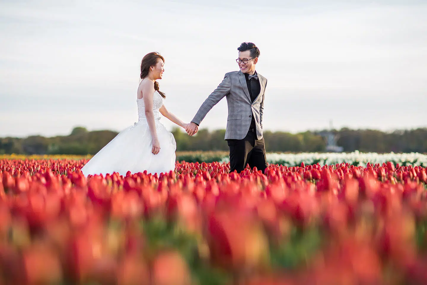 Pre wedding shoot Keukenhof couple strolling through fields of tulips