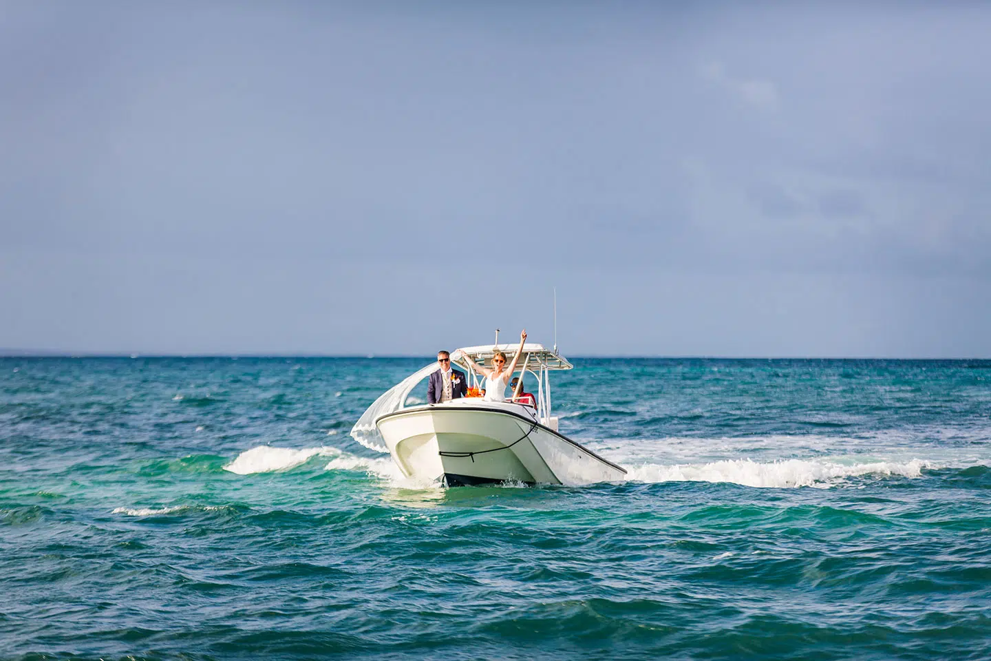 Couple arrives on a boat at their Caribbean wedding