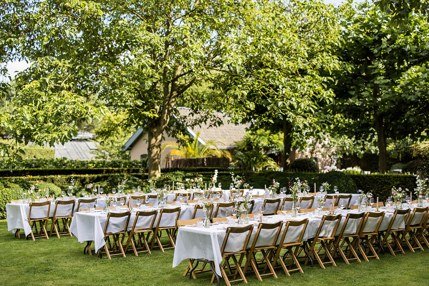 Lange eettafels bij een bruiloft in de tuin van trouwlocatie Domaine d'Heerstaayen