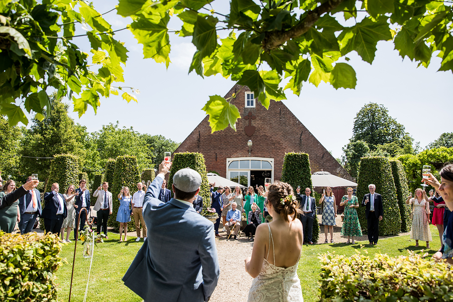 Bruidspaar proost op hun bruiloft bij het Hoogh Huys in Winssen