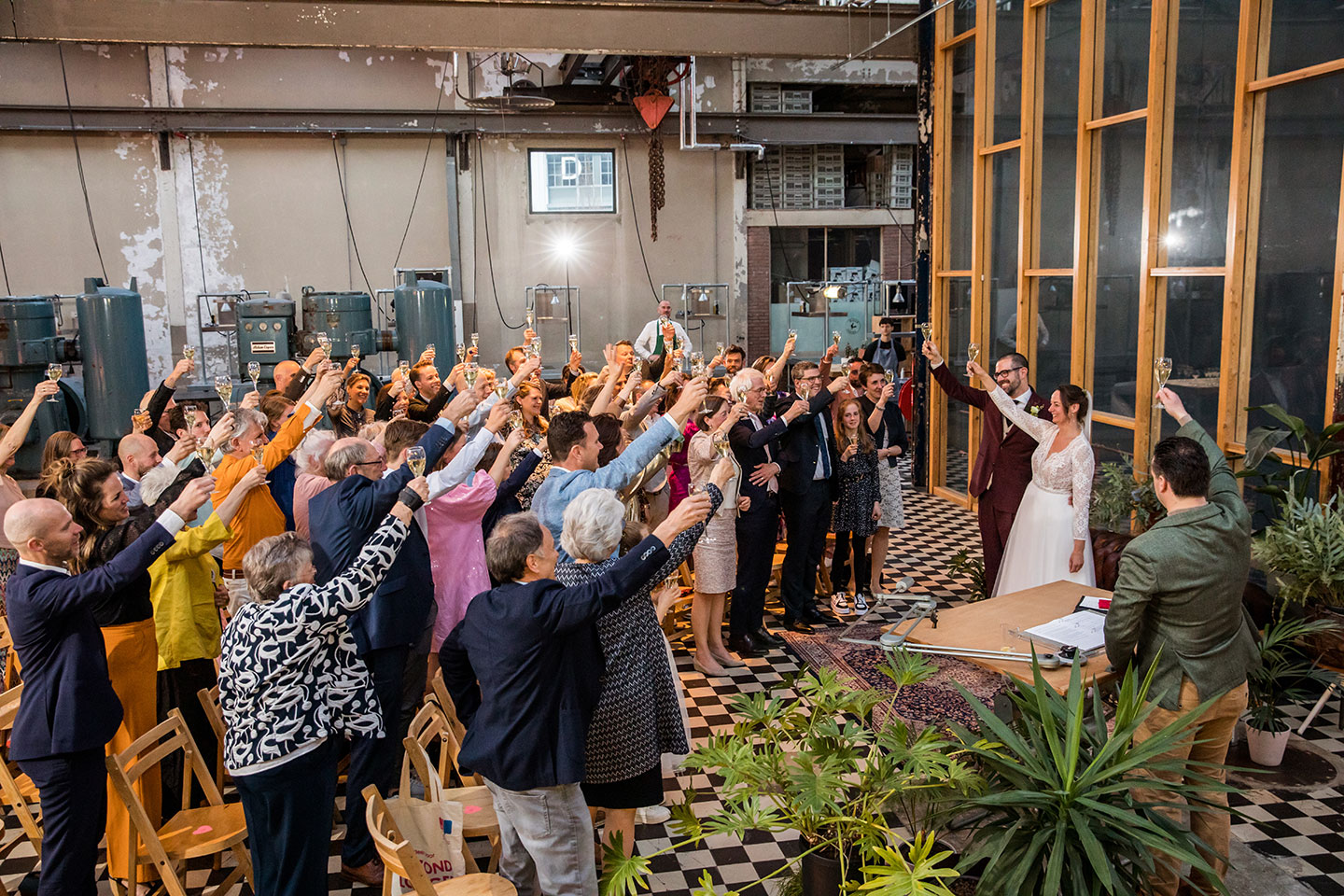 Bruidspaar proost met gasten op hun huwelijk bij Radio Royaal in Eindhoven