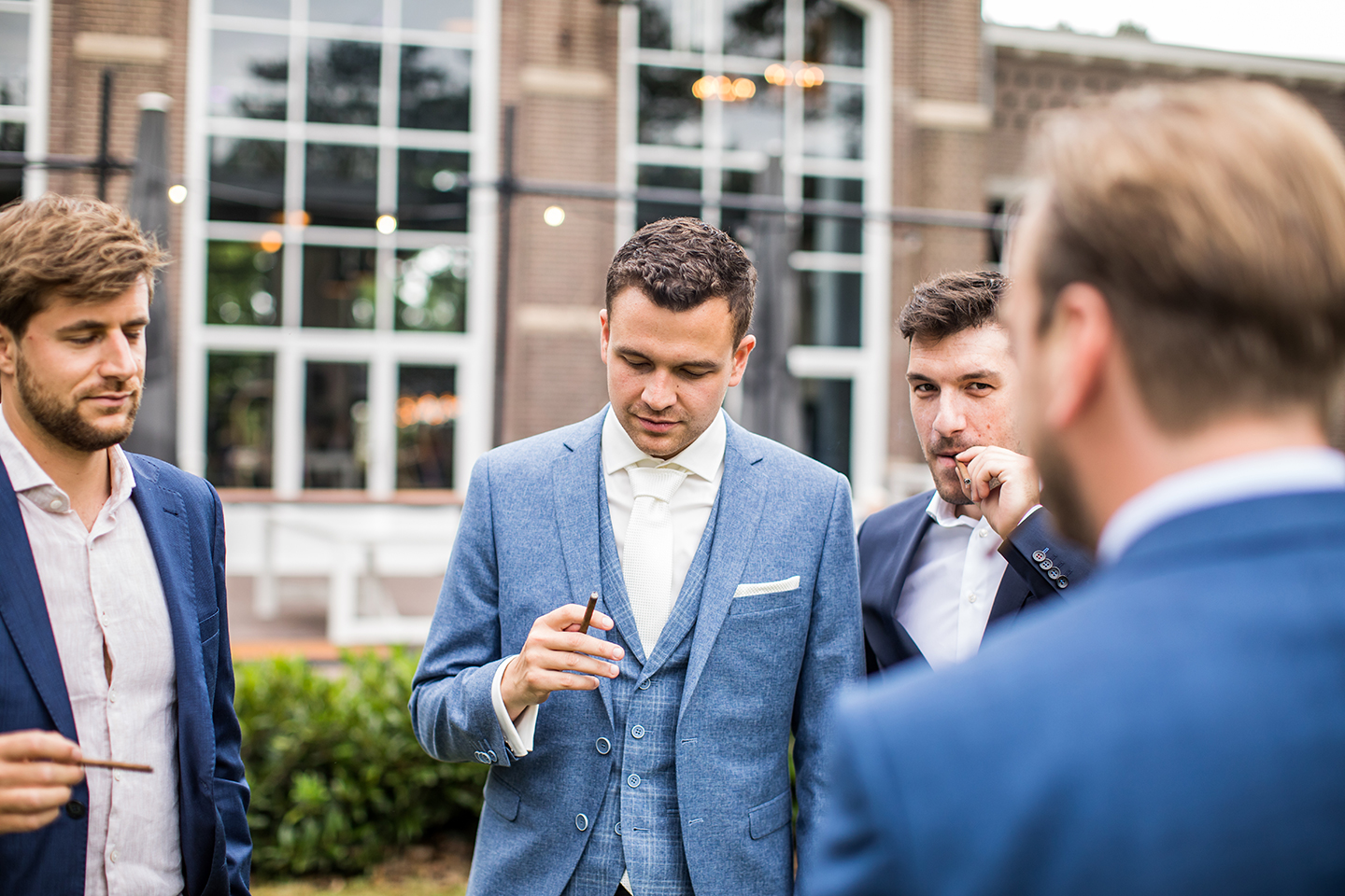 Bruidegom rookt sigaar met zijn beste vrienden tijdens een bruiloft bij het Ketelhuis Landgoed de Grote Beek in Eindhoven
