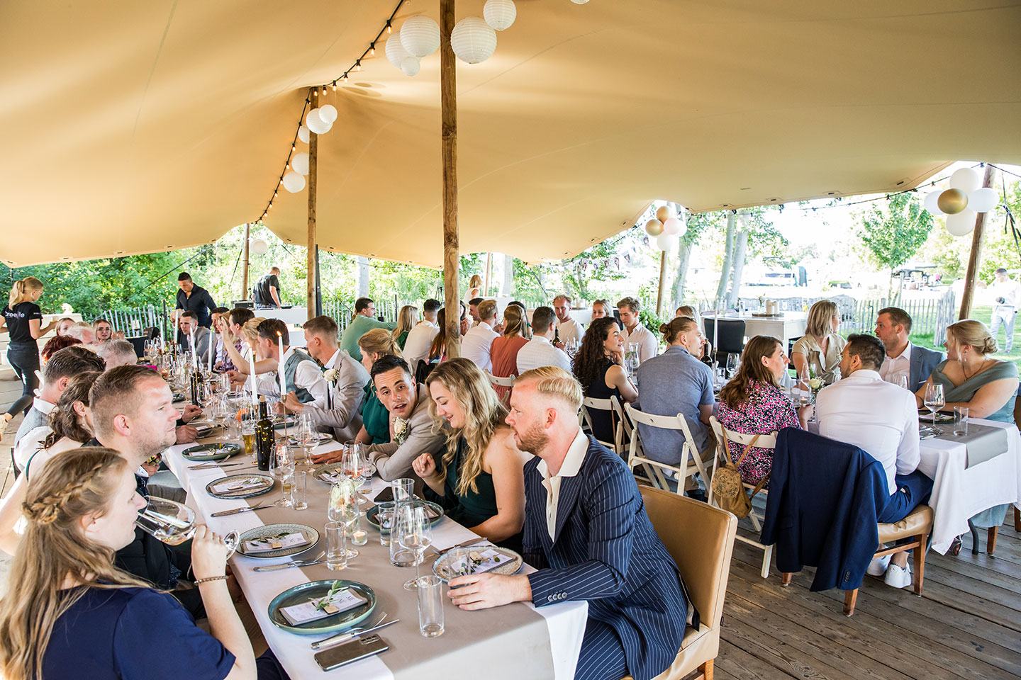 Daggasten tijdens het diner onder mooie stretch tenten van een bruiloft bij Breezze in Brielle