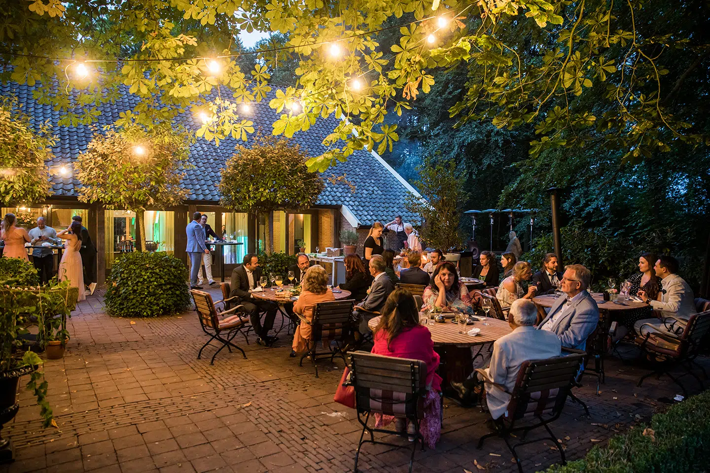 Gasten borrelen buiten tijdens een huwelijk bij de Havixhorst