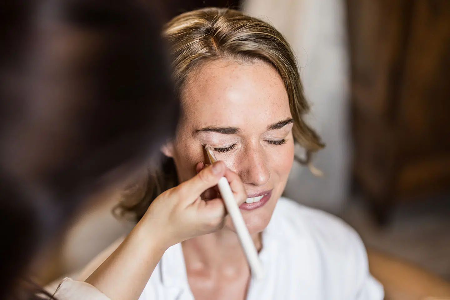 Bruid in de make-up tijdens haar bruiloft bij Kasteel Henkenshage