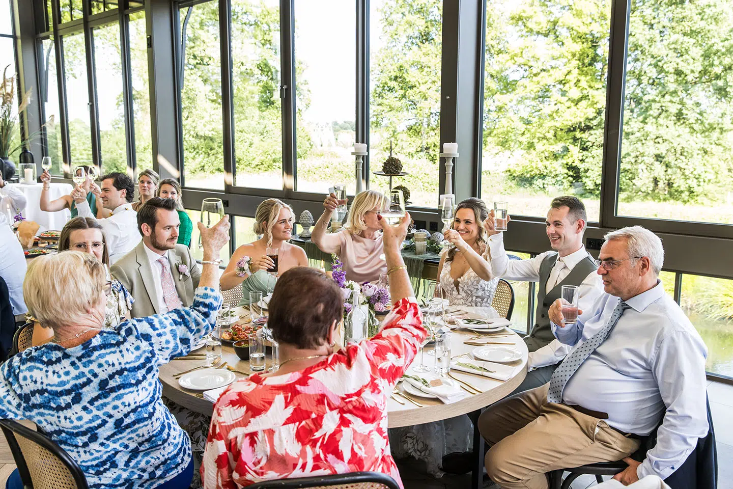 Bruidspaar proost met gasten tijdens bruiloft bij Kasteel Daelenbroeck