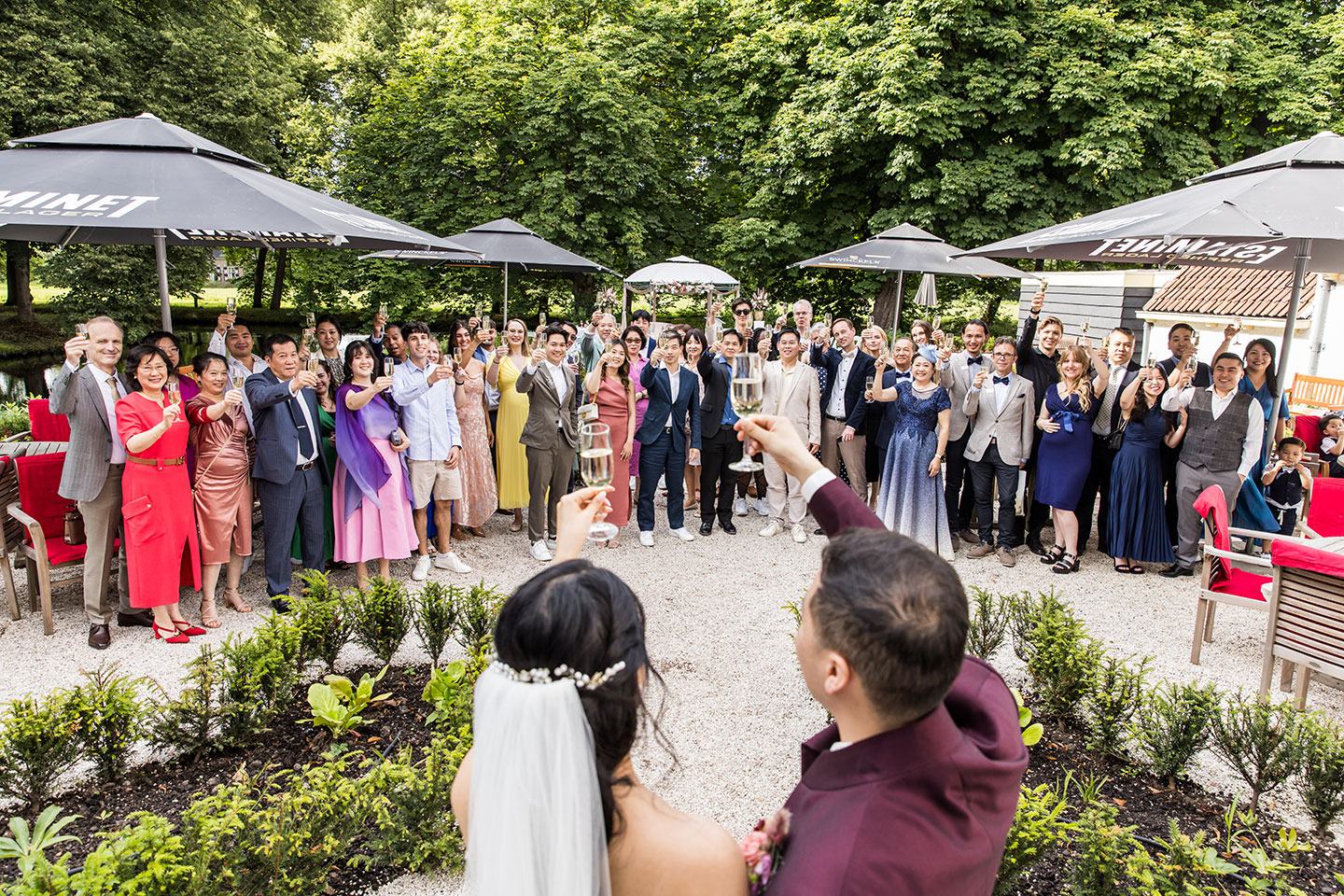 Bruidspaar proost met gasten tijdens hun. bruiloft bij Kasteel van Rhoon
